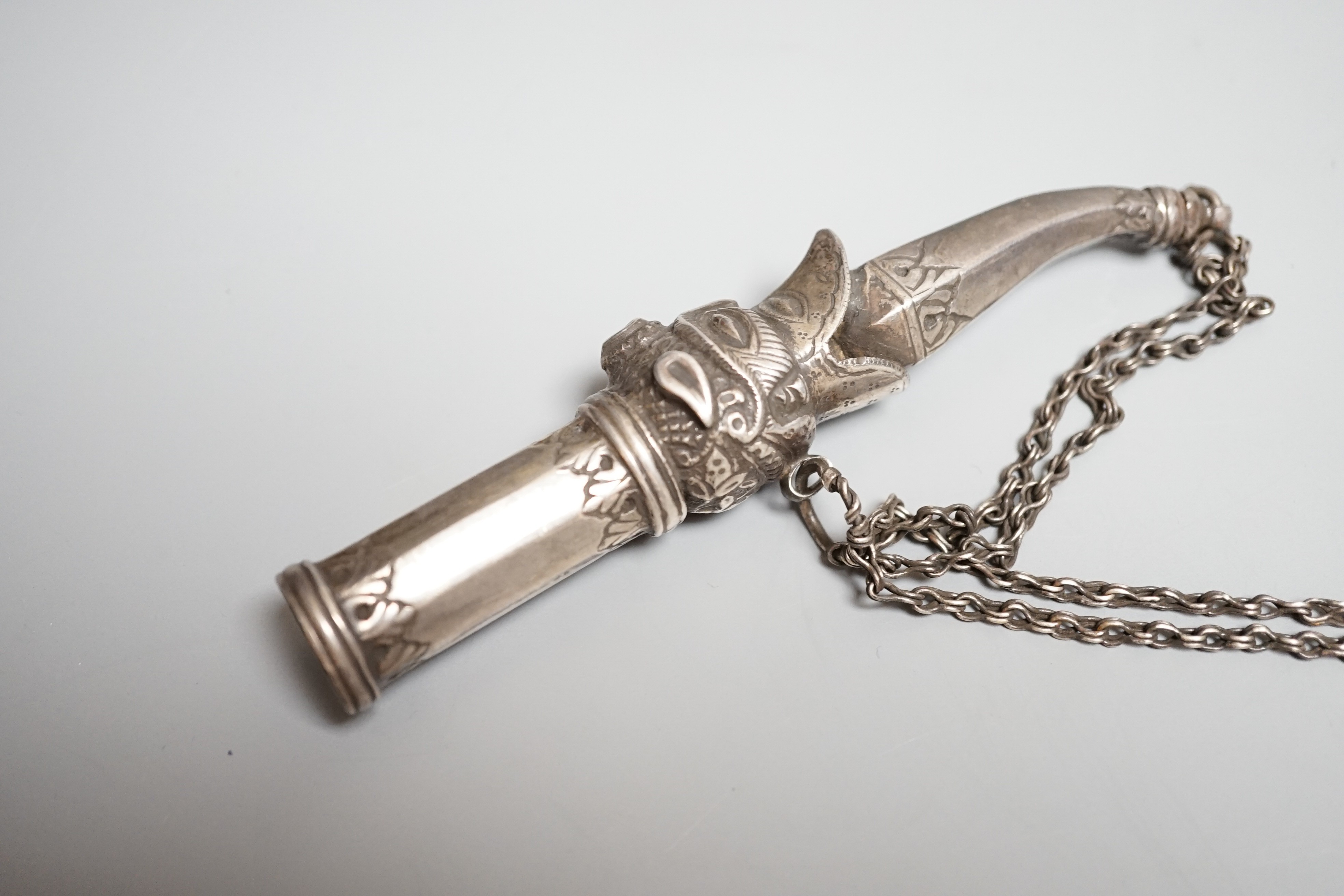 An Indian silver mouthpiece (munal) for the hookah, 19th century, formed with a makarra issuing from a lion’s mouth, silver stopper and chains, length 12.5cms